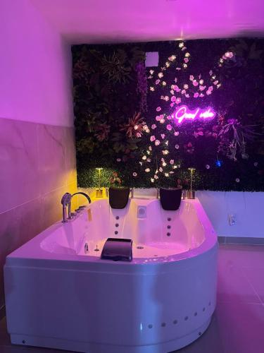 a bath tub in a room with purple lighting at Logement entier avec jacuzzi proche futuroscope in Naintré