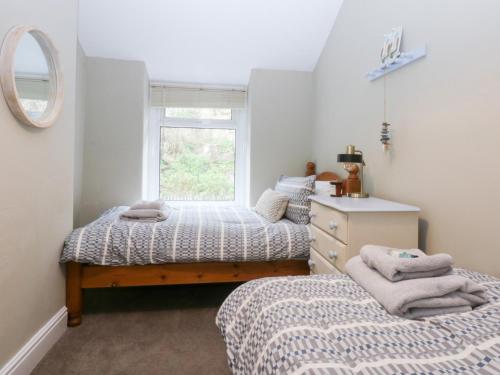 a bedroom with two beds and a mirror at 3 Bay View Terrace in Llandudno