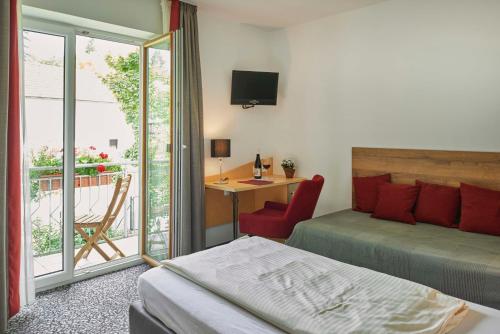 a bedroom with a bed and a desk with a chair at Gasthaus Alter Wirt in Oberneuching