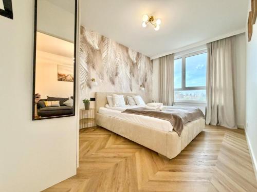a bedroom with a bed and a large window at Jarzebinowa Loft III by JumpInHere in Nowy Dwór Mazowiecki