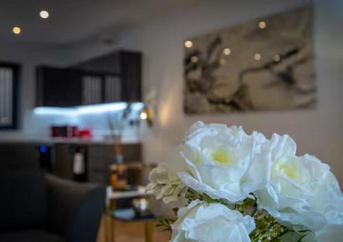 a vase filled with white flowers on a table at Super King Penthouse Minutes from Arndale Centre - Pass the Keys in Manchester