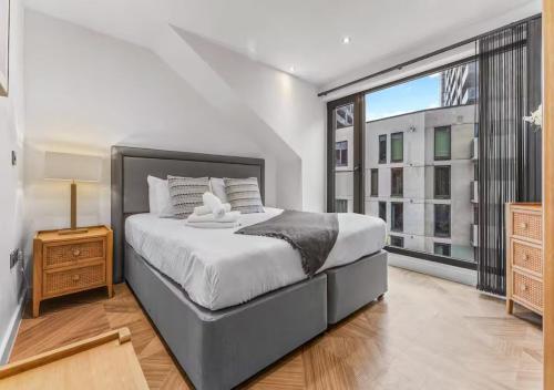 a bedroom with a large bed and a large window at Super King Penthouse Minutes from Arndale Centre - Pass the Keys in Manchester