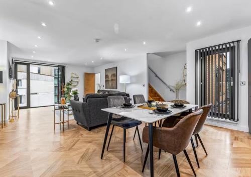 a dining room and living room with a table and chairs at Super King Penthouse Minutes from Arndale Centre - Pass the Keys in Manchester