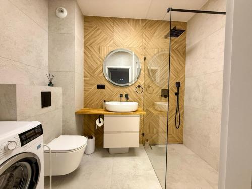a bathroom with a sink and a toilet and a mirror at Jarzebinowa Loft III by JumpInHere in Nowy Dwór Mazowiecki