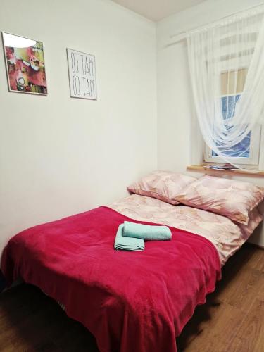 a bed with two towels on a red blanket at Dzień dobry w Szczytnej in Szczytna