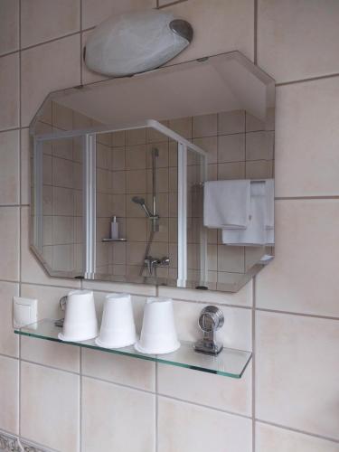 a mirror on a wall in a bathroom at Berki Vendéglő és Hotel in Körmend