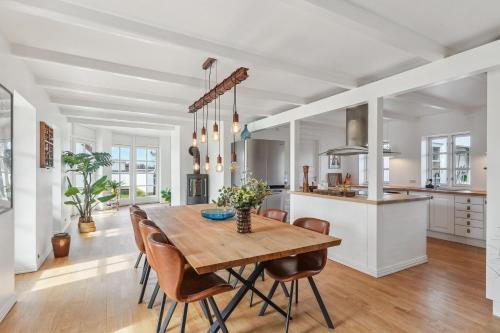 a kitchen and dining room with a wooden table and chairs at Holstvej 21 Holiday Home For 12 Guests With An Extra Bonus in Blokhus