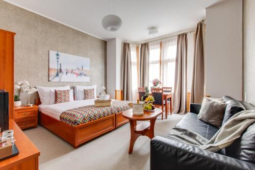 a hotel room with a bed and a couch at Kafka Prague rooms in Prague