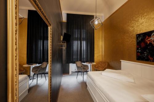 a bedroom with a mirror and a bed and a table at Hotel Goldene Spinne in Vienna