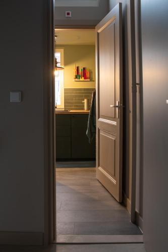an open door leading to a kitchen with a sink at The Painters Loft sleeping among the art in Haarlem