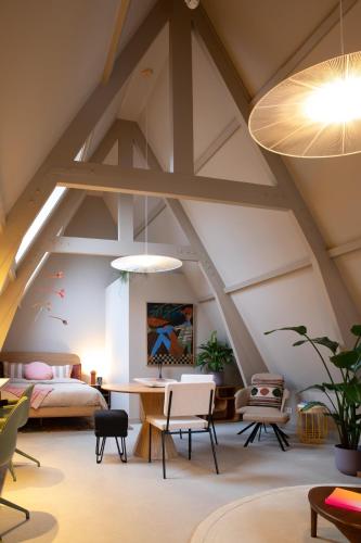 a attic bedroom with a bed and a table at The Painters Loft sleeping among the art in Haarlem