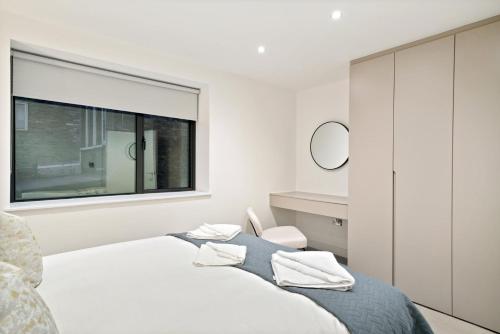 a white bedroom with a bed and a window at Executive 1 & 2 Bed Apartments in heart of London FREE WIFI by City Stay Aparts London in London