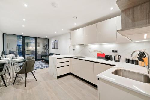 a kitchen with white cabinets and a dining room at Executive 1 & 2 Bed Apartments in heart of London FREE WIFI by City Stay Aparts London in London