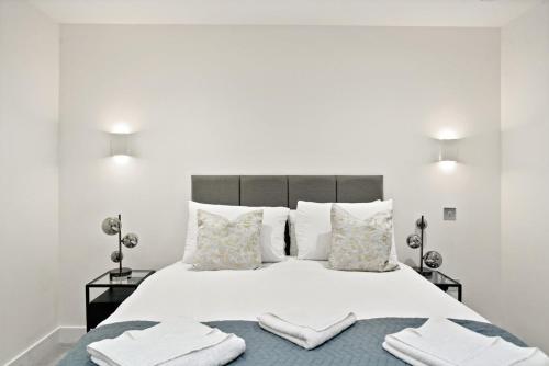 a white bedroom with a large bed with towels on it at Executive 1 & 2 Bed Apartments in heart of London FREE WIFI by City Stay Aparts London in London