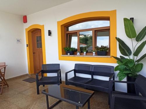 a living room with a couch and chairs and a window at Porto D'Abrigo - Alojamento Local in Sardoal