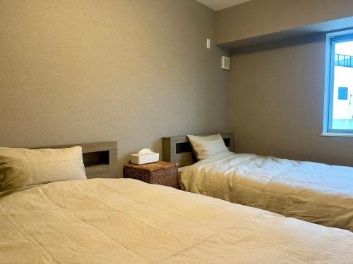 a bedroom with two beds and a window at Villa Okubo Akiya in Yokosuka