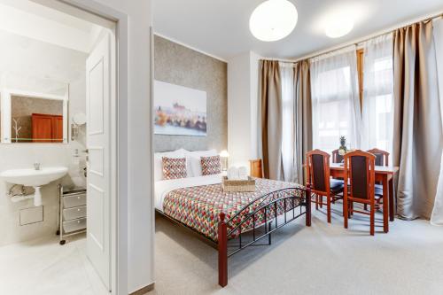 a bedroom with a bed and a table and a bathroom at Kafka Prague rooms in Prague