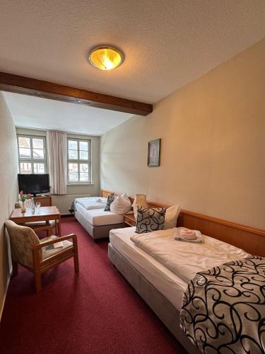 a hotel room with two beds and a tv at Hotel Zum Kanzler in Stolberg