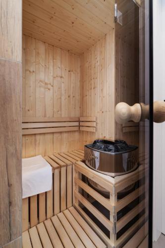 a wooden sauna with a tub in it at Apartamenty EN Zator in Podolsze