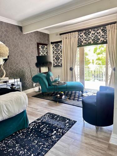 a living room with a blue couch and a table at CHERRY NEST at Madeliefie in Welkom