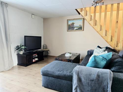 a living room with a couch and a tv at Apartment Norrgården in Genevad