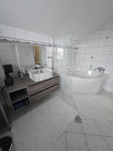 a bathroom with a tub and a sink and a mirror at Bella Vista in Stažnjevci