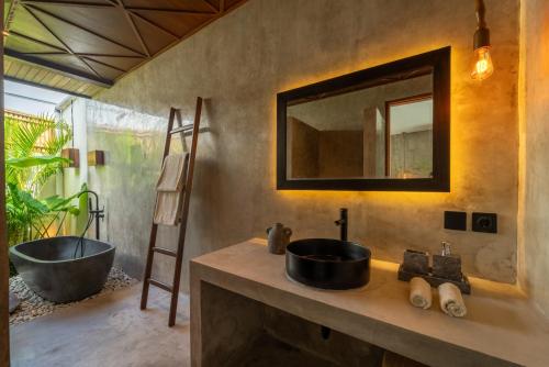 a bathroom with a sink and a bath tub at Atol Villas in Uluwatu