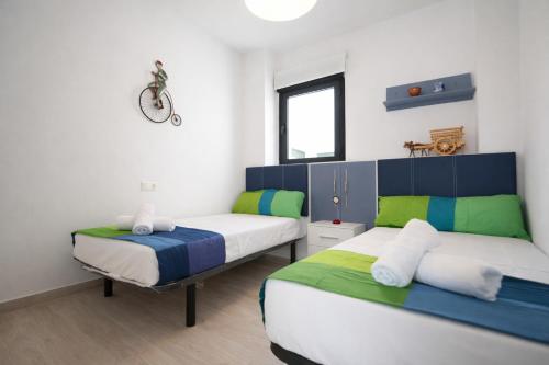 a bedroom with two beds and a window at AL045 Pinada Beach III La Mata in La Mata