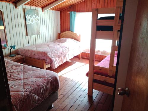 a bedroom with two beds and a bunk bed at Hospedajes y Cabañas Marisol in Curacautín