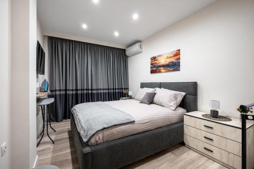 a bedroom with a bed and a desk in a room at Plovdiv Luxury 1BR * Free Parking * Rowing Base in Plovdiv
