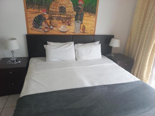 a bedroom with a large bed with two night stands at THE ROSE BnB in Soweto