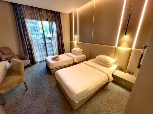 a hotel room with two beds and a mirror at Rawsheh Boutique Hotel in Beirut