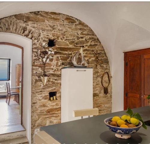 a kitchen with a stone wall and a bowl of fruit at Villa Emmanuella in Centuri
