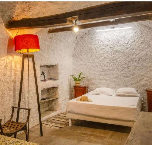 a bedroom with a bed and a lamp and a chair at Villa Emmanuella in Centuri