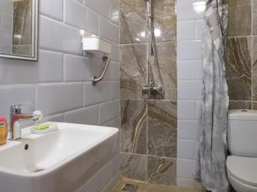 a bathroom with a sink and a shower and a toilet at Tekrour- La case des hotes -Chambre lumineuse proche plage in Mbour