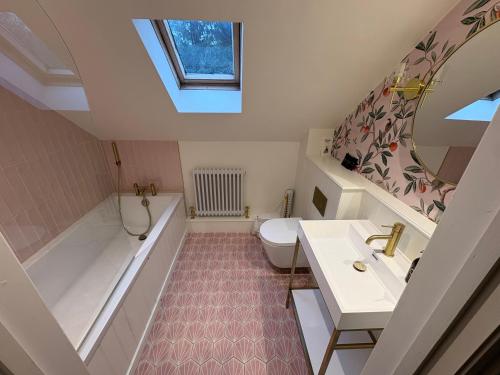 a bathroom with a sink and a tub and a toilet at No33 WOODLANDS BOUTIQUE COTTAGE in Heacham