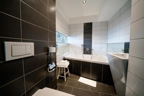 a bathroom with a tub and a toilet and a sink at Hotel Goldene Spinne in Vienna