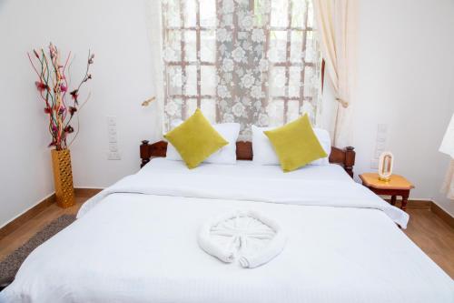 a bedroom with two white beds with yellow pillows at Arusha Oasis Executive Residence in Arusha