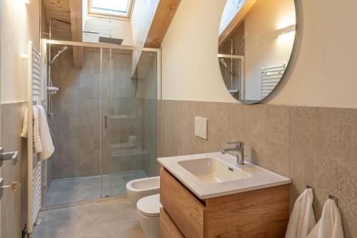a bathroom with a sink and a toilet and a mirror at Duplex Cermis in Cavalese