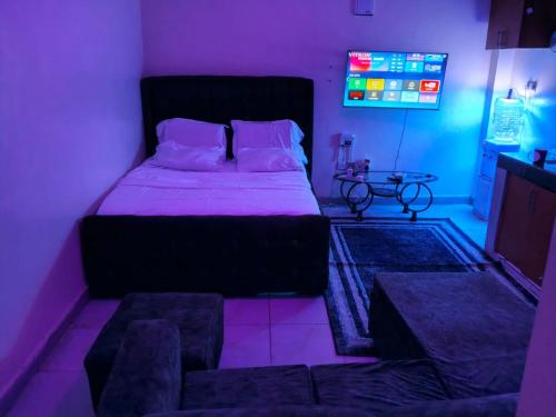 a bedroom with a bed in a purple room at Silverline Suite in Kitengela 