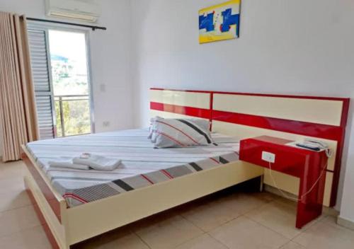 a bedroom with a large bed with a red frame at Villa Maior Hotel in São Roque