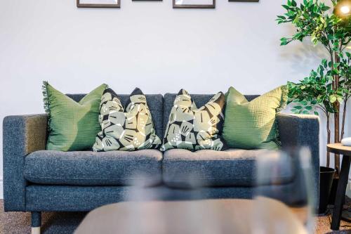 a blue couch with pillows on it in a living room at Spacious 4 Bed Home in Crewe by 53 Degrees Property! Perfect for Groups & Families in Crewe