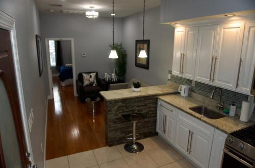 a kitchen with white cabinets and a counter top at New York private room 29 in West New York