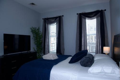 a bedroom with a bed with blue walls and windows at New York private room 29 in West New York