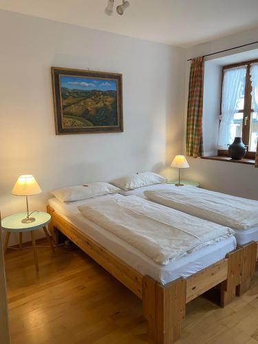 two twin beds in a room with two lamps at Appartements am Schlossberg in Starnberg