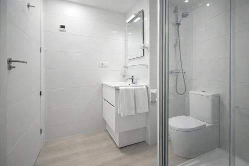 a white bathroom with a toilet and a shower at AL045 Pinada Beach III La Mata in La Mata