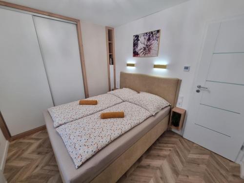 a small bedroom with a bed with two objects on it at Exclusive Home Apartman in Miskolc