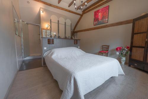a bedroom with a white bed in a room at La Maison Rouziès in La Bastide-lʼÉvêque