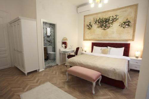 a bedroom with a large bed and a table at Villa Korzo in Bitola