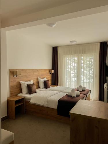 a bedroom with a large bed and a window at Apartments & rooms Concept Nordica in Žabljak